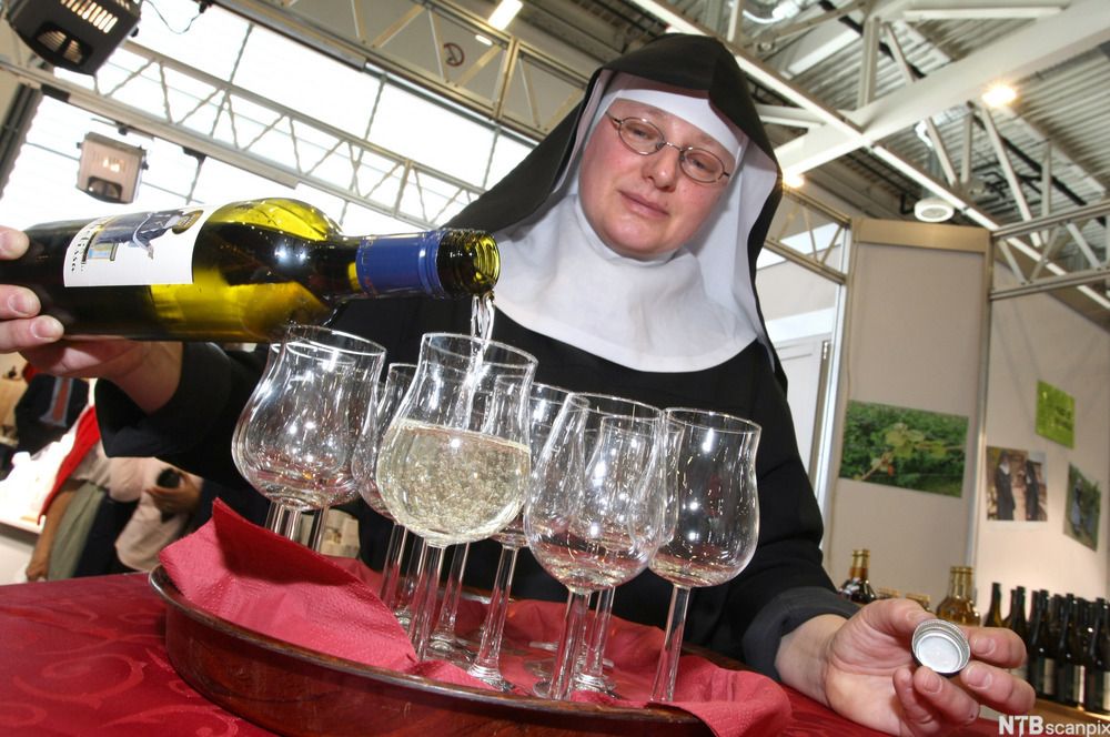 En nonne heller hvitvin i vinglass på et serveringsbrett. Foto.