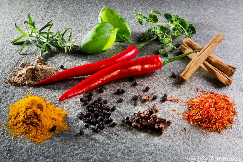 Ulike typar krydder lagde opp på ein benk. Foto.