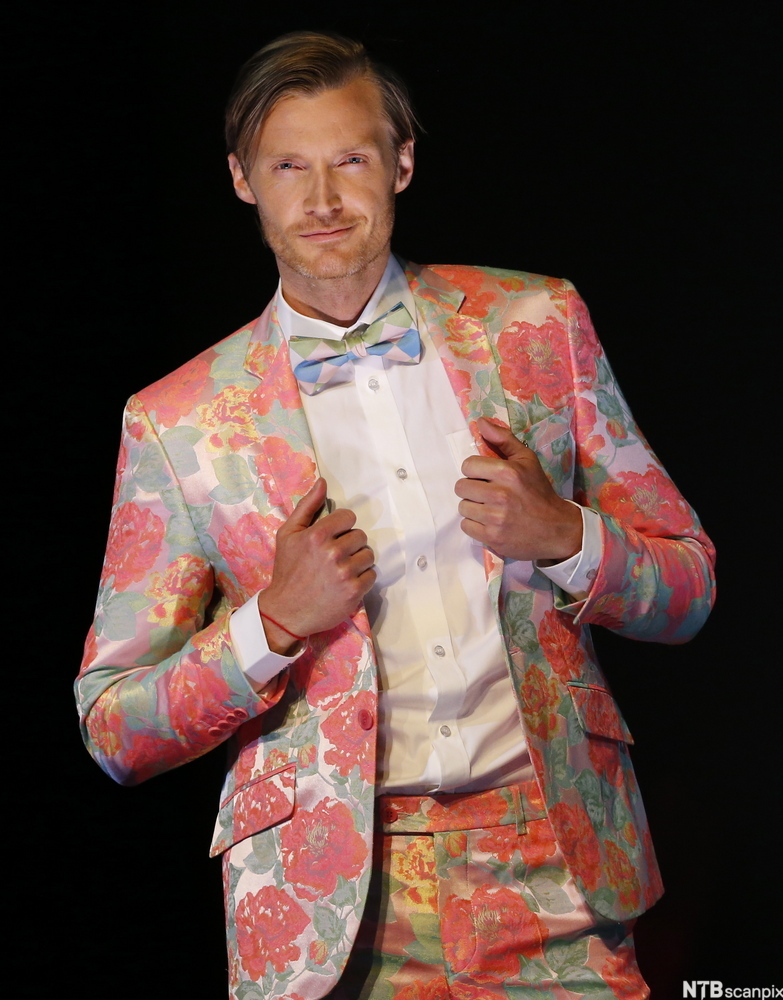 En mann med fargerik dress i blomstrete mønster. Foto. 