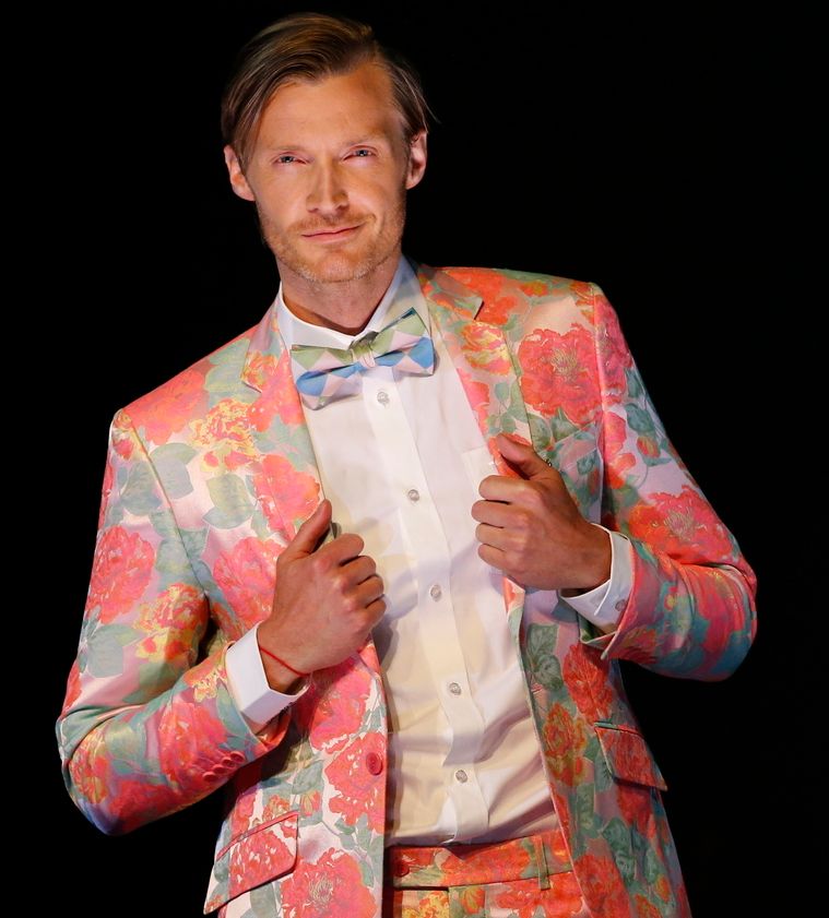 En mann med fargerik dress i blomstrete mønster. Foto.