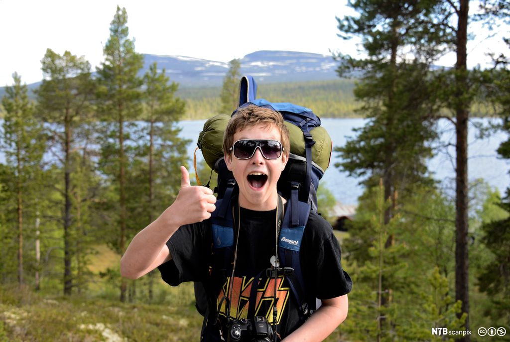 Ung gut på fottur viser tommel opp. Foto.
