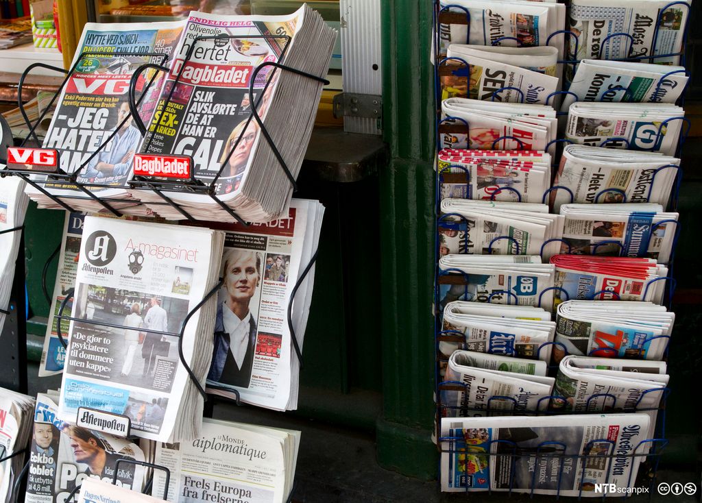 Aviser står i salsstativ. Foto.