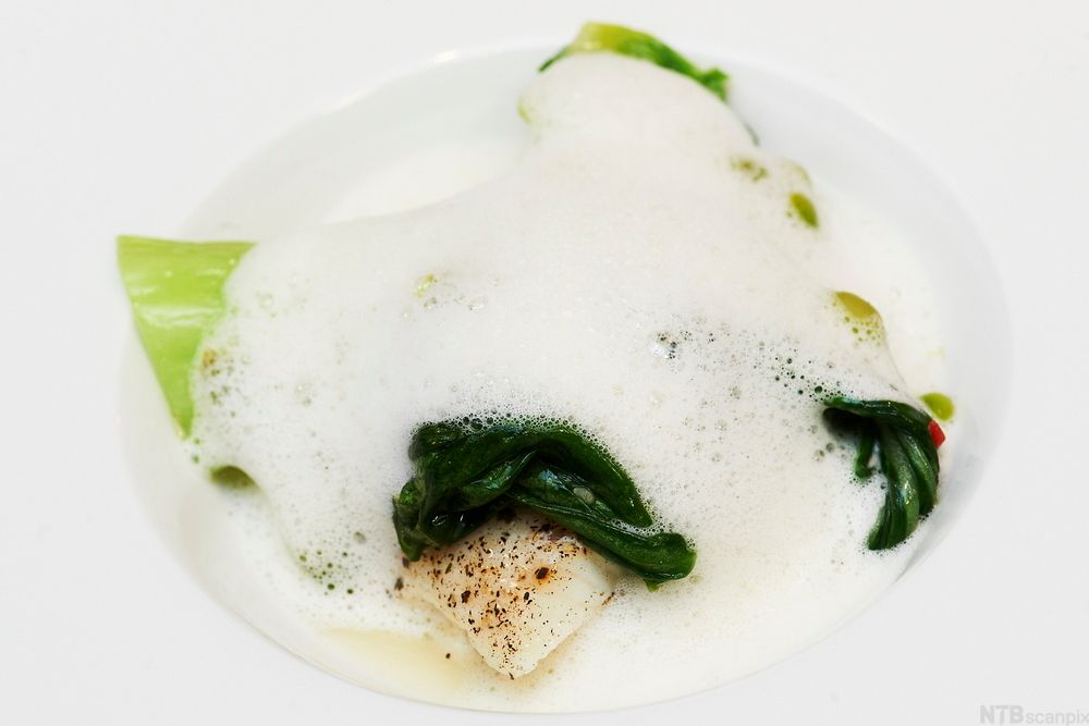 En tallerken med et stykke bakt kveite med tangskum. Foto.