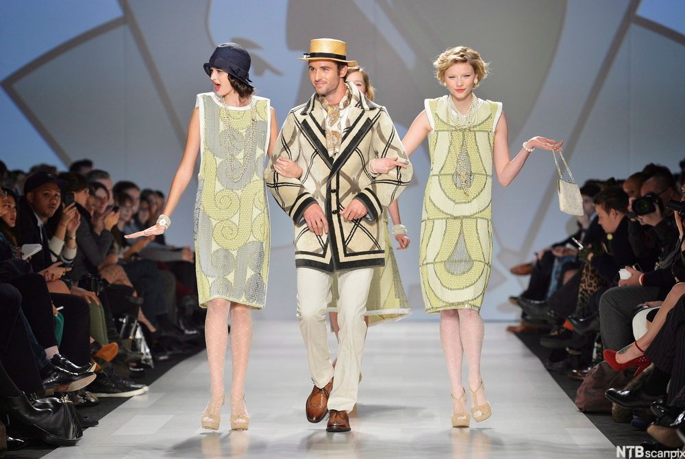 Modeller går arm i arm på catwalk. Foto.