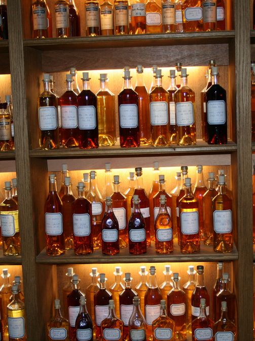 Konjakkflasker som står til utstilling i hyller. Foto.