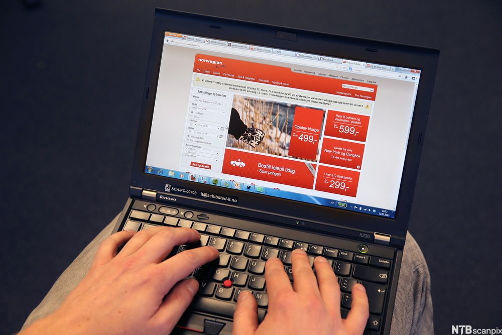 Ein person ser på flyprisar på ein berbar PC. Foto.