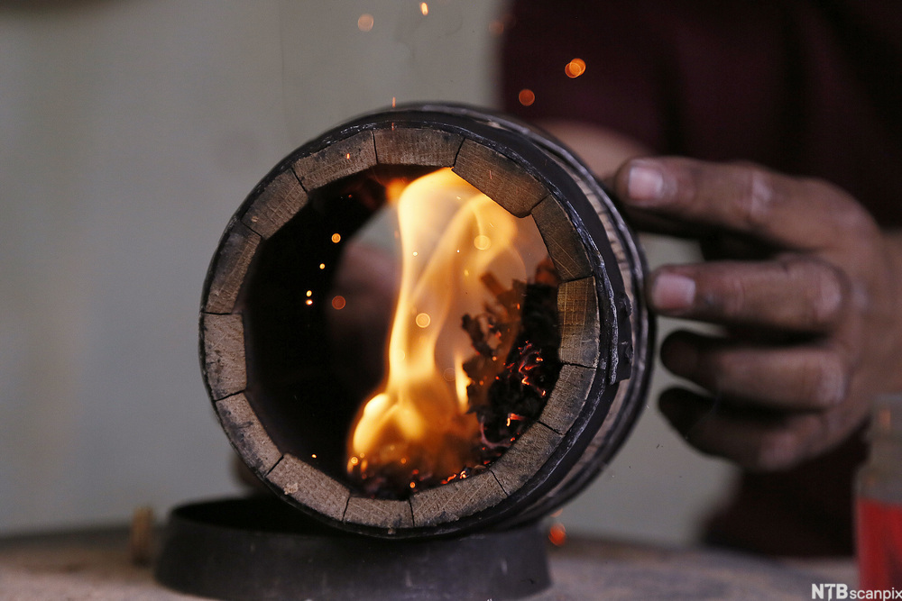 Produksjon av tønner til tequila. Tønna blir brent inni. Foto.