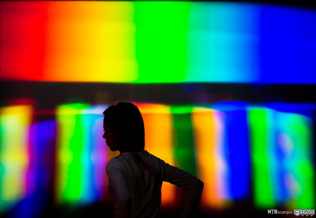 Siluette foran en et lysfargespekter. Foto.