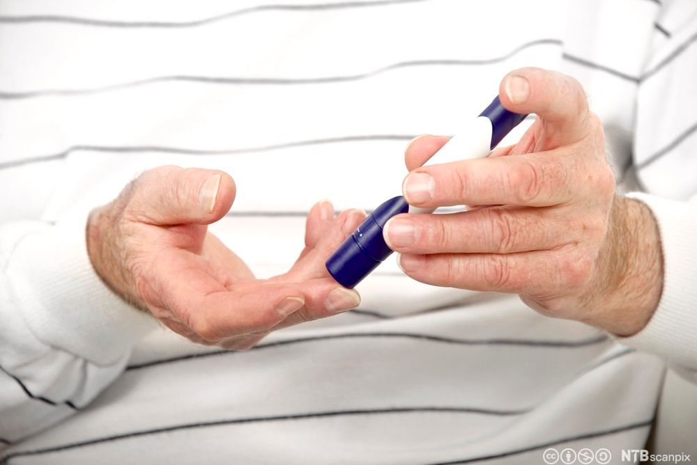 Nærbilde av at en person stikker seg i fingeren for å teste blodsukkeret. Foto.