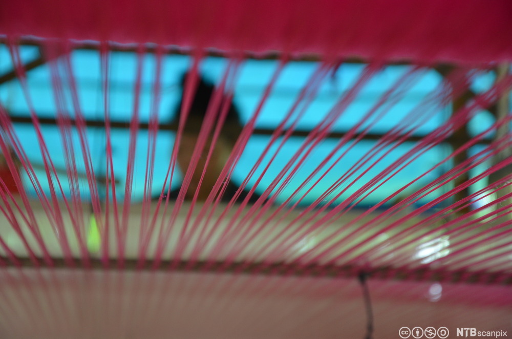 Nærbilde av renning og innslag i en vev. Foto.