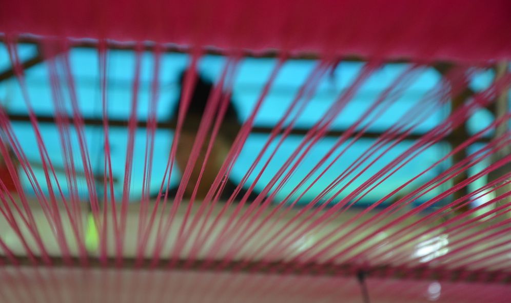 Nærbilde av renning og innslag i en vev. Foto.