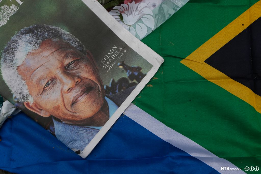 A newspaper front page picture and a South Africa flag are left in tribute for Nelson Mandela