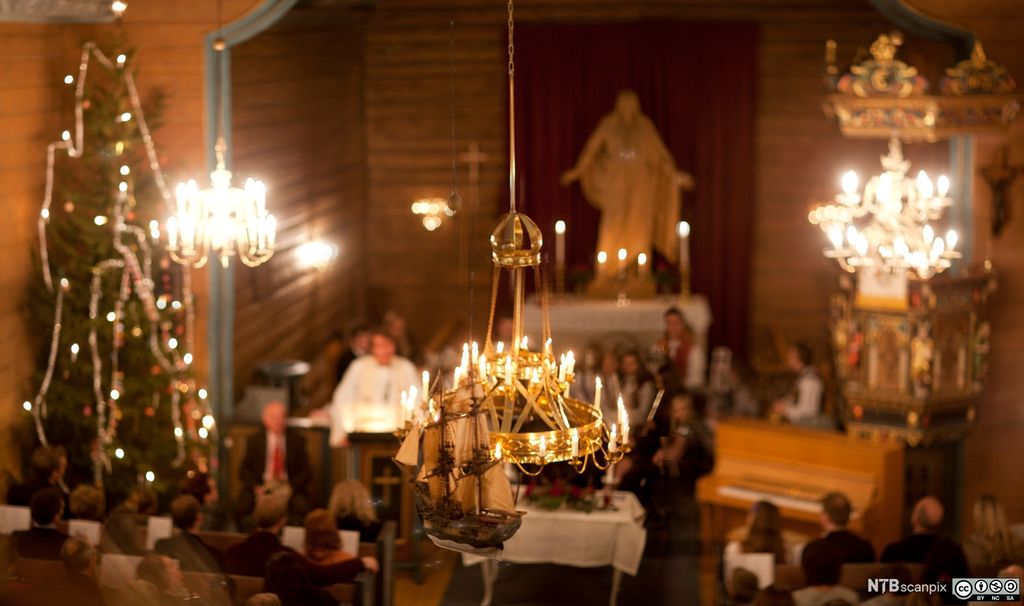 Ei norsk kyrkje på julafta pynta med juletre og lys. Foto. 