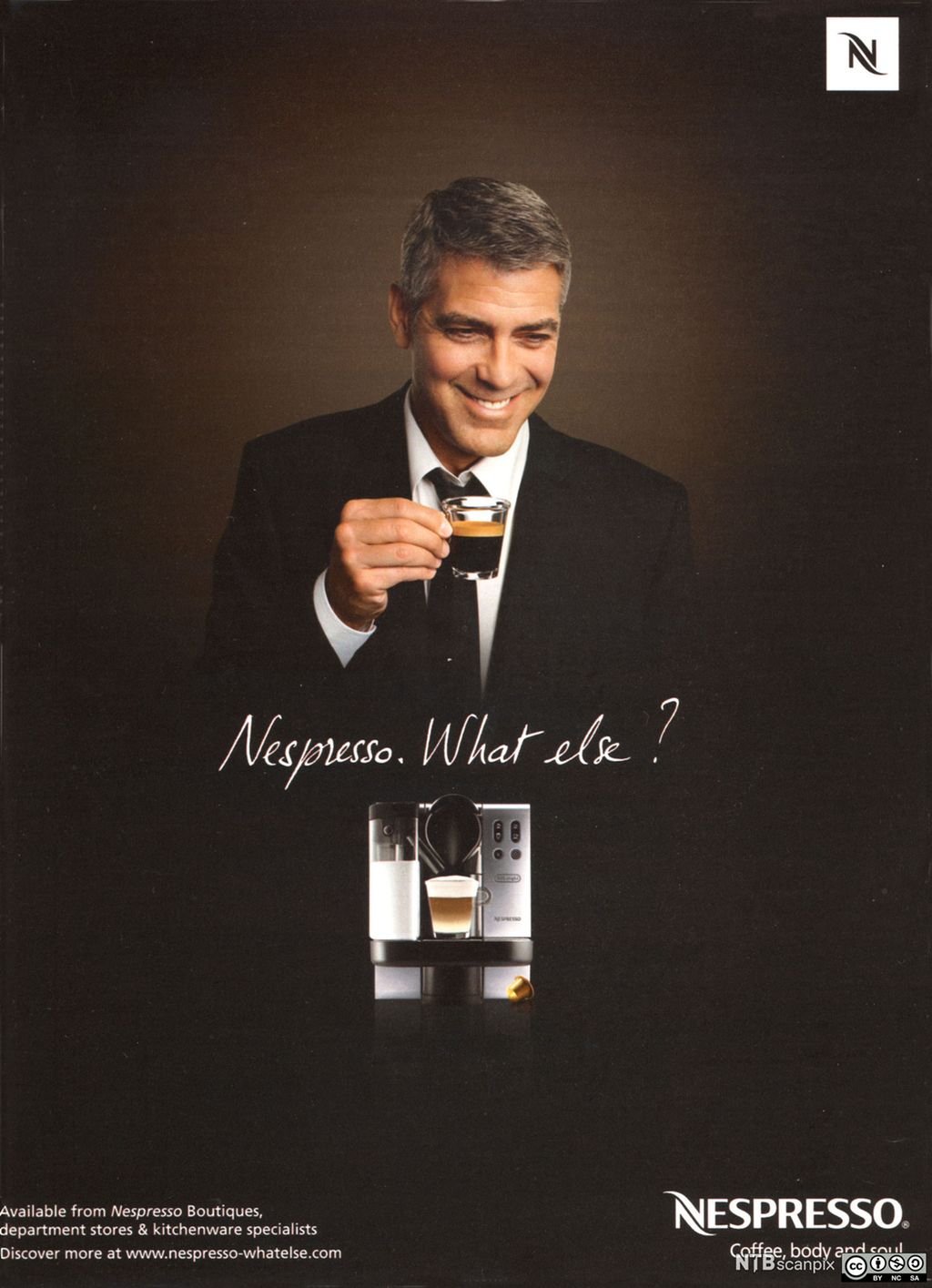 Reklameplakat for Nespresso. Bildet som dekker plakaten, har mørk bakgrunn og viser en smilende George Clooney i mørk dress og med en espressokopp i hånda. Under ham er teksten "Nespresso. What else?" og en kaffemaskin. Øverst i høyre hjørne er Nespresso-logoen. Nederst i høyre hjørne står det "Nespresso. Coffee, body and soul". Nederst i venstre hjørne står følgende: "Available from Nespresso Boutiques, department stores & kitchenware specialists. Discover more at www.nespresso-whatelse.com." Plakat.