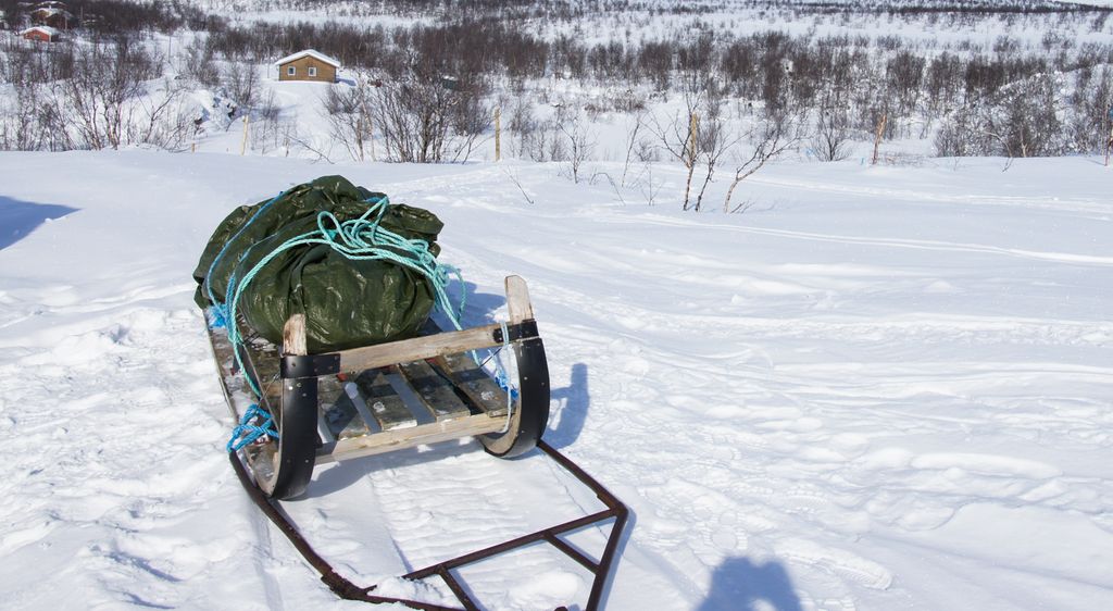 Slede der lasta er pakket inn i en presenning. Foto.