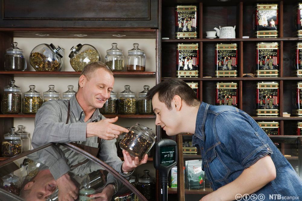 Kunde luktar på te i ein tebutikk. Foto.