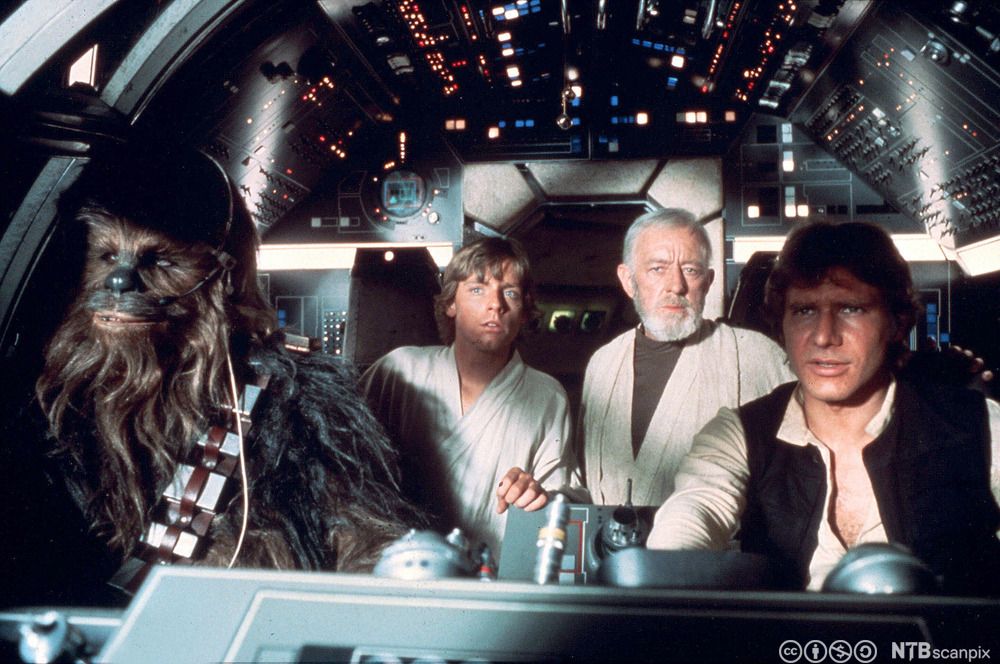 Star Wars-karakterene Chewbacca, Luke Skywalker, Obi-Wan Kenobi og Han Solo sitter i et romskip. Filmfoto.