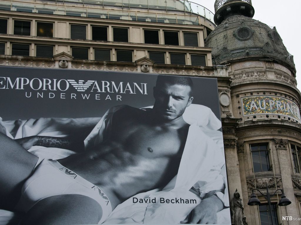 Fotballspiller David Beckham poserer i boksershorts på stor reklameplakat på husfasade. Foto.