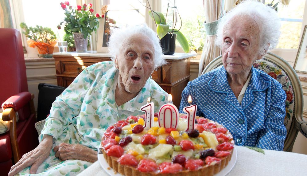To gamle damer feirer 101-årsdag med kake. Foto.
