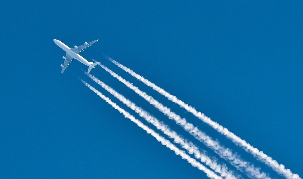 Fly i lufta med hvite kondensstriper etter seg. Foto.