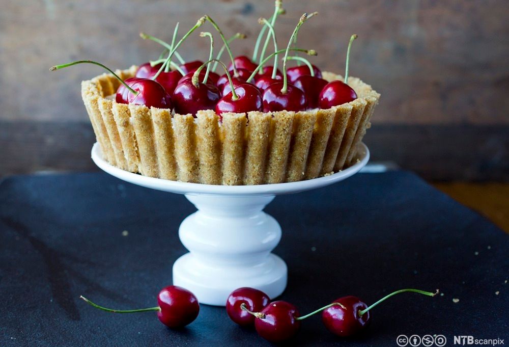 Tertedeig fylt med mange kirsebær. Foto.