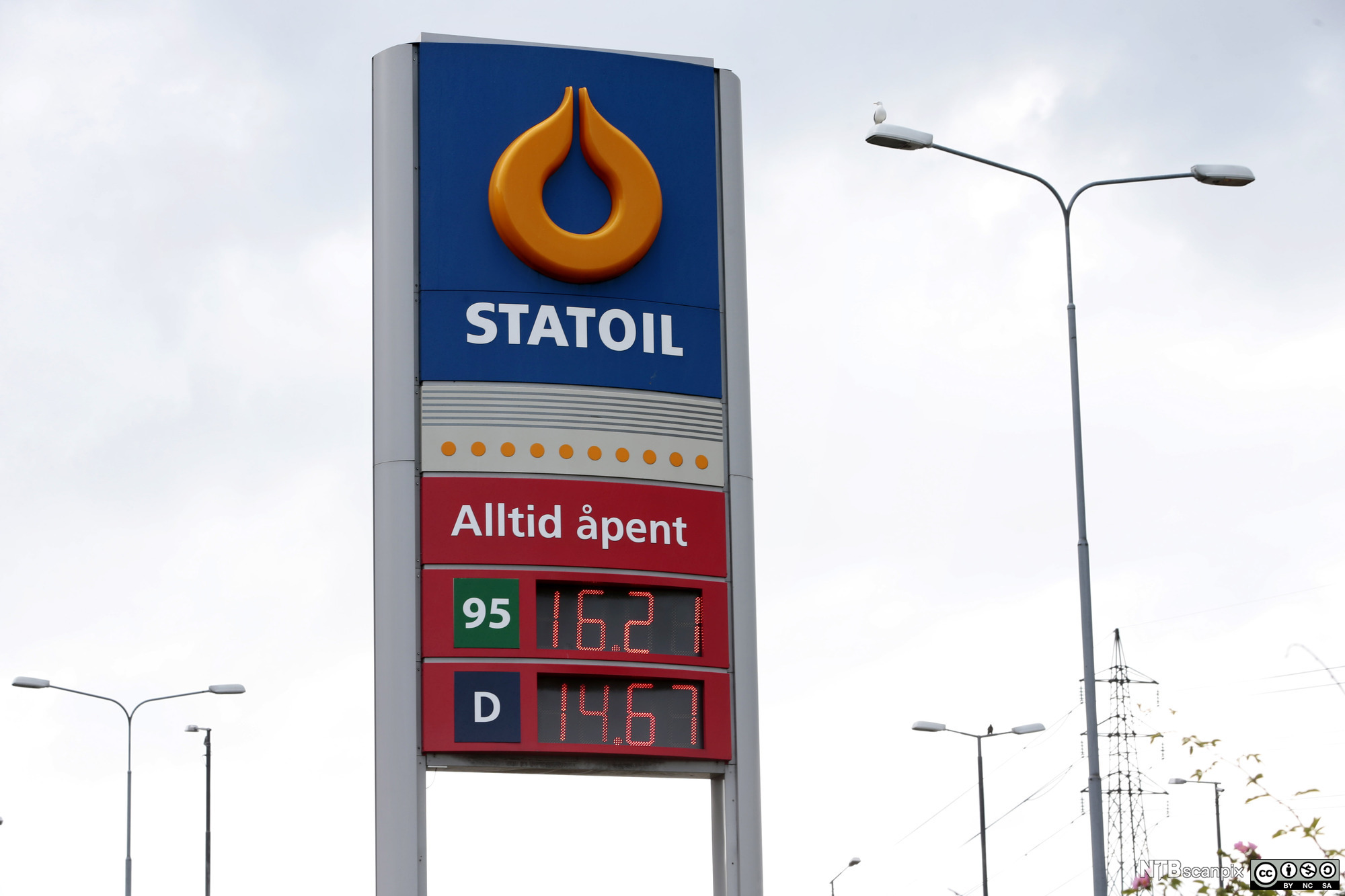 Pris på drivstoff vises i et display på en bensinstasjon. Det står "Alltid åpent" og følgende siffer: "95: 16.21" og "D: 14.67". Foto.