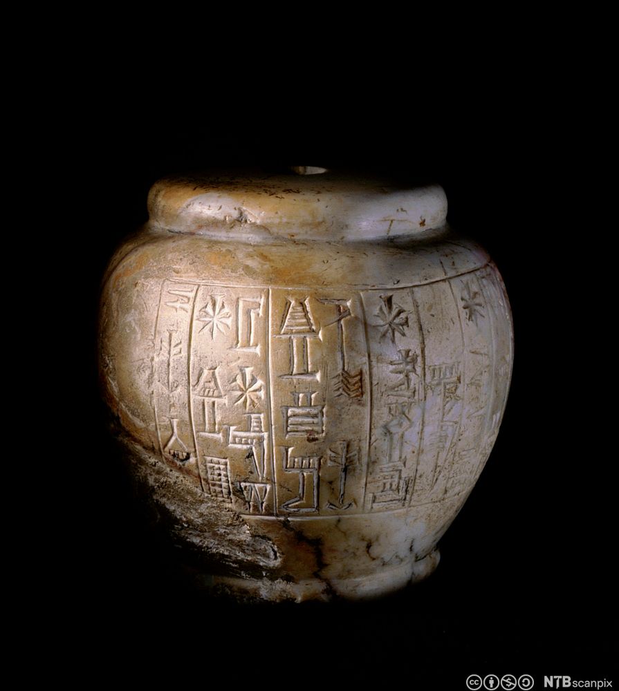 Rundt septerhode av marmor med inngraveringer.  Foto.