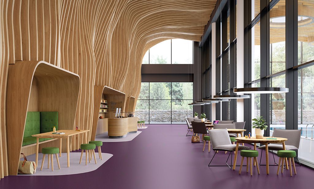 Moderne interiør med dekorative trespiler på veggen og sittegrupper på lilla vinylbelegg. Foto.