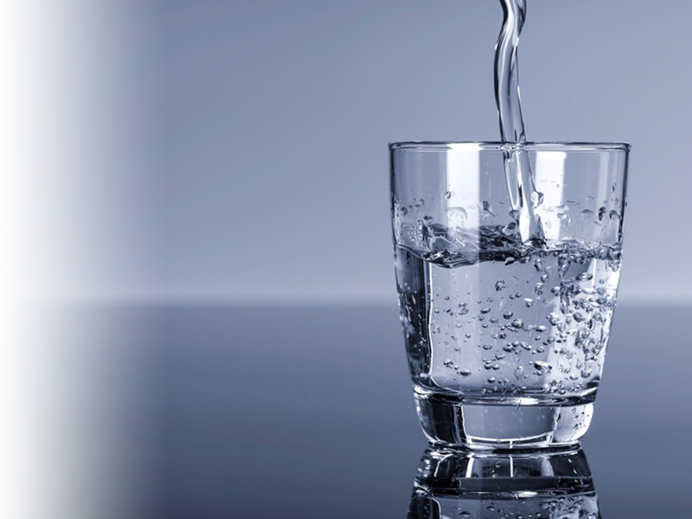 Vatn blir tømt i glass. Foto.