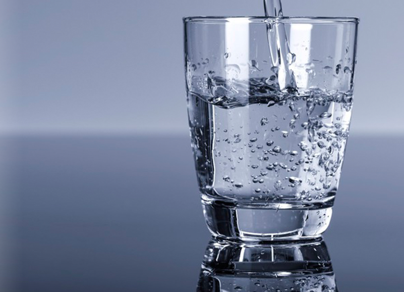 Vatn blir tømt i glass. Foto.