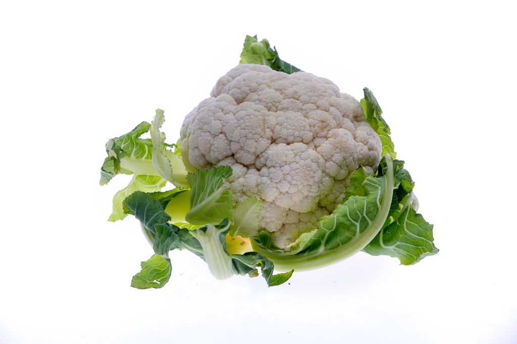 Hel blomkål mot hvit bakgrunn. Foto.