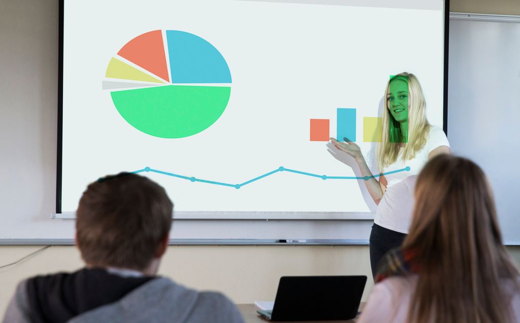 Ung kvinne viser fram statistisk framstillling på lerret. Foto.