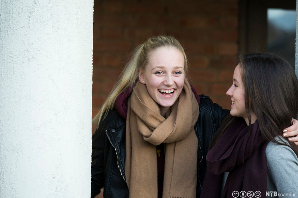 To jenter snakker sammen. Foto.