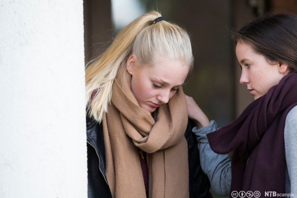 Jente får trøst av venninne. Foto.