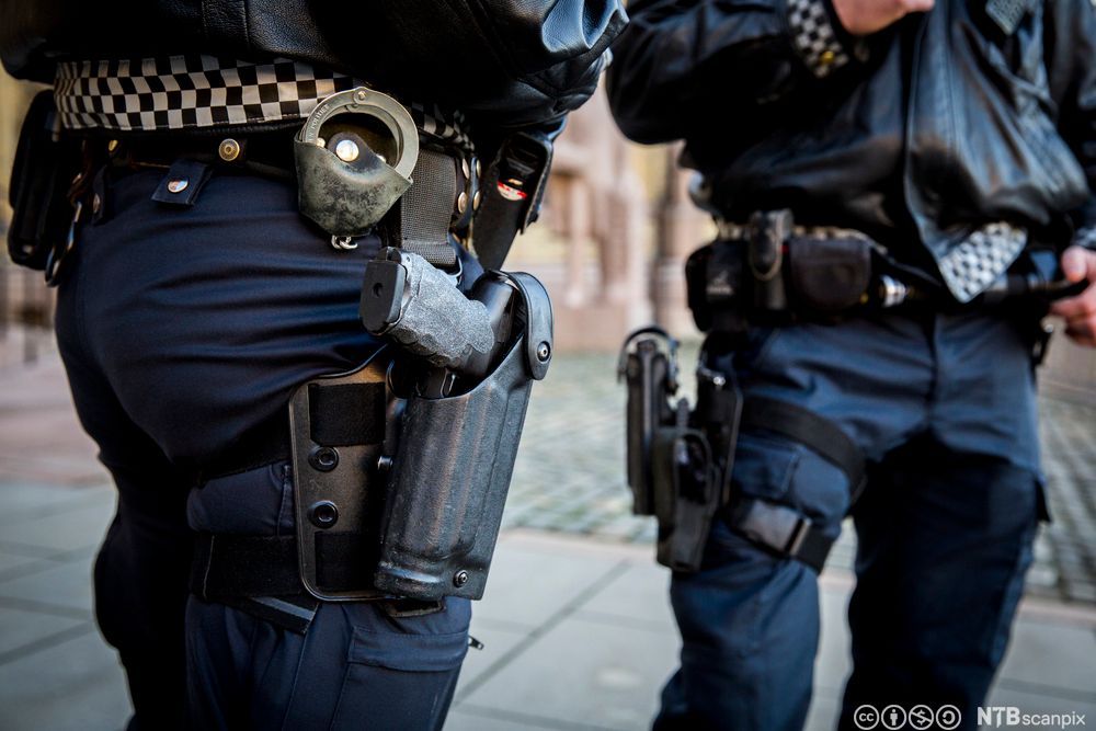 Bevæpnet politi. To politibetjenter i uniform bærer håndvåpen. Foto.