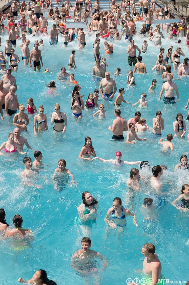 Foto av et stort antall unge mennesker som bader i et utendørs badeanlegg i Tyskland.