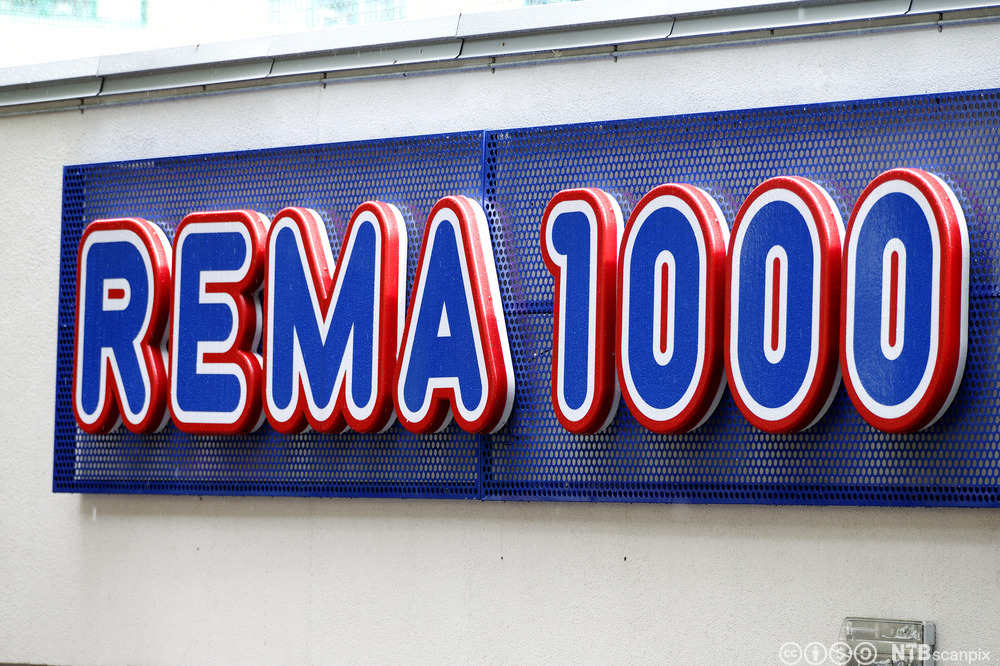 Foto av logoen til Rema 1000 på en vegg.