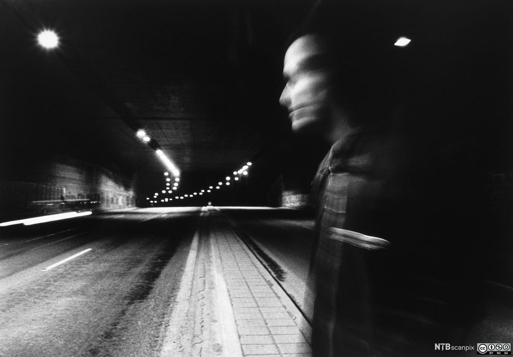 Silhuett av mann i mørk gate. Foto.