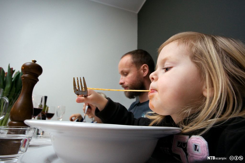 Barn som spiser spagetti. Foto.