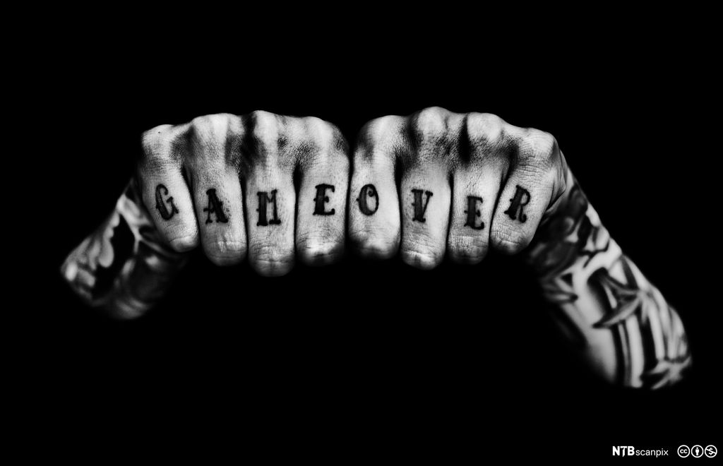 Tatoverte fingre med ordene «Game over». Foto.