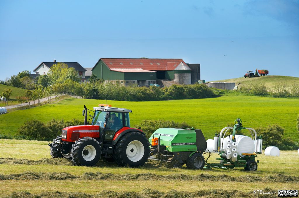 Traktor med rundballepresse. Foto.