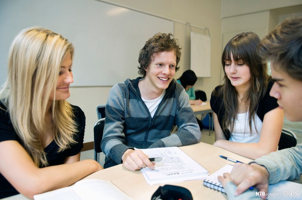 Elevar sit rundt pult i klasserom. Foto.