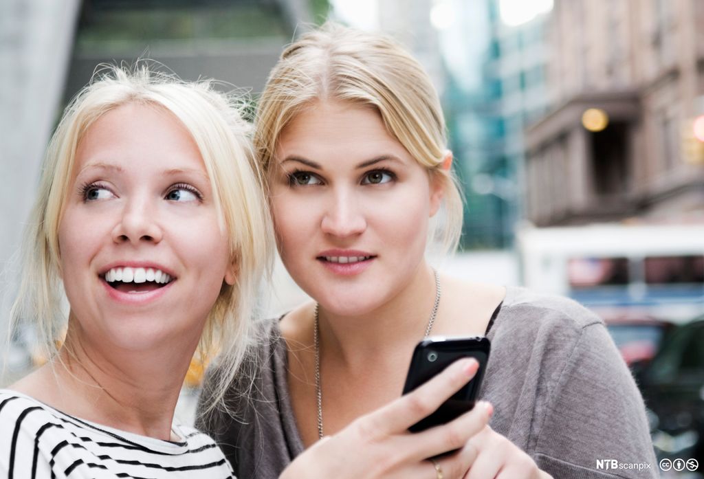 To jenter med mobiltelefon. Foto.