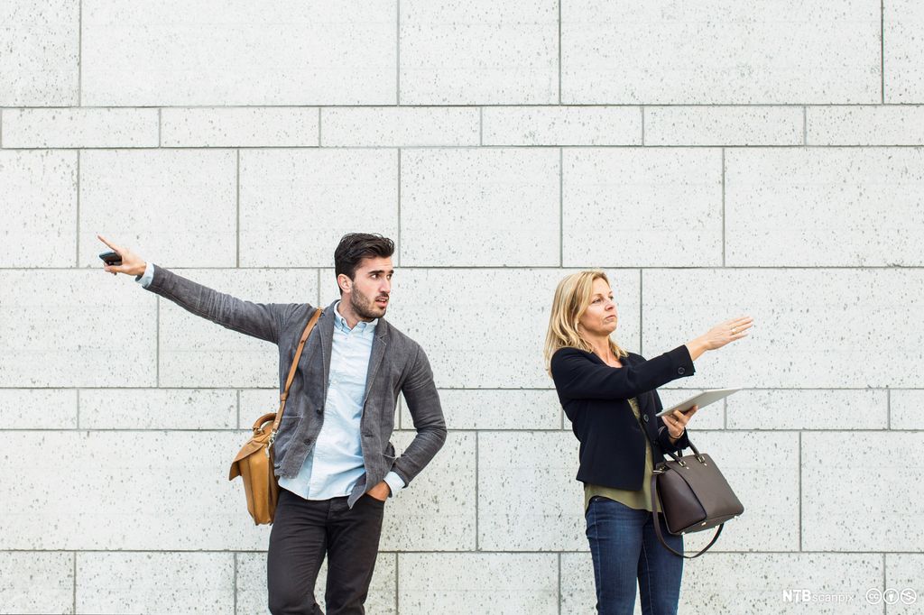 To voksne peker i hver sin retning. Bilde.