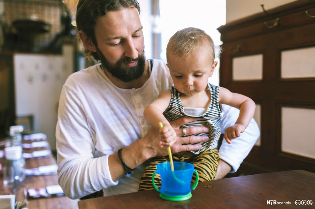 Mann med liten sønn på restaurant. Foto.