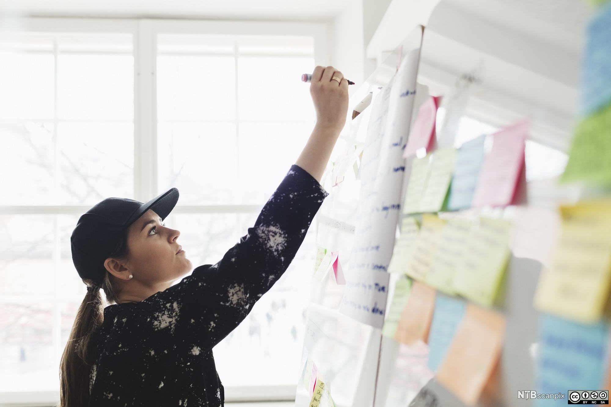 Forretningsutvikler skriver på whiteboard-tavle. Foto.