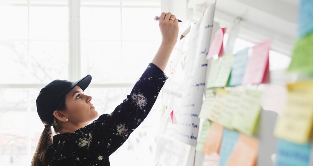 Forretningsutvikler skriver på whiteboard-tavle. Foto.