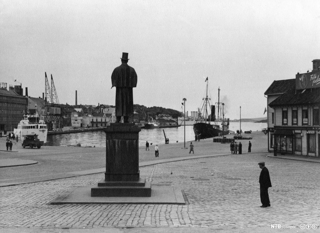 Mann på sokkel skuer ut over vågen i Stavanger. Foto.
