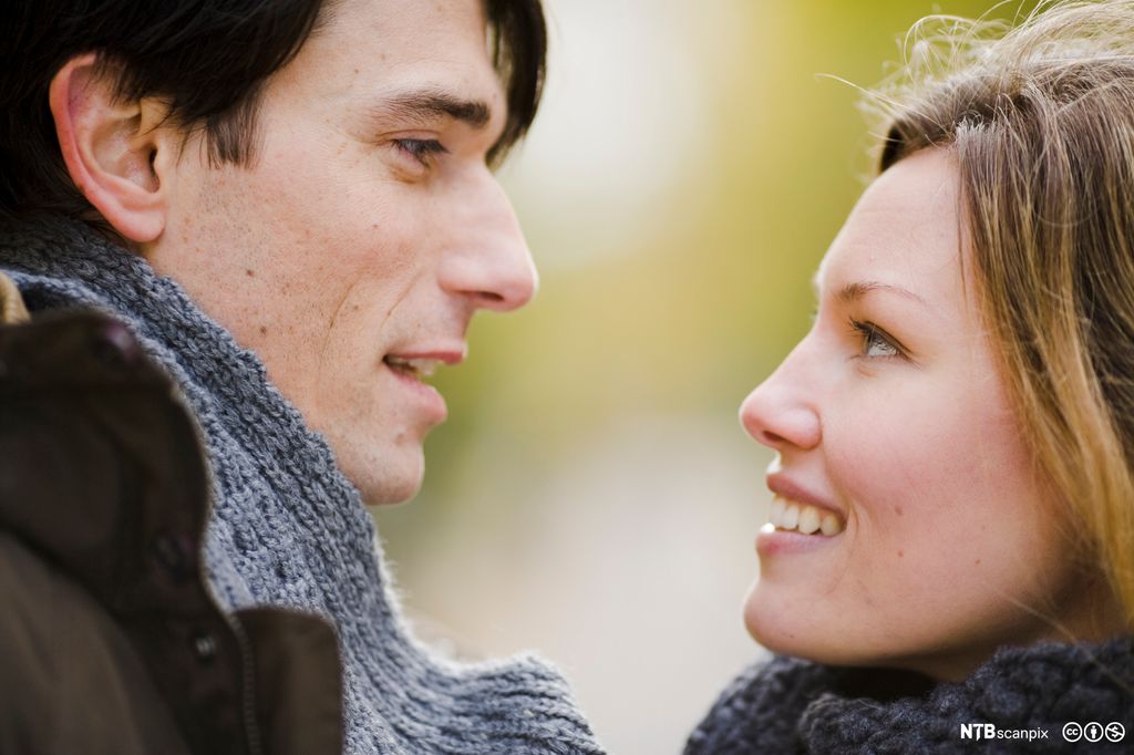 Mann og kvinne står nær inntil hverandre. Foto.