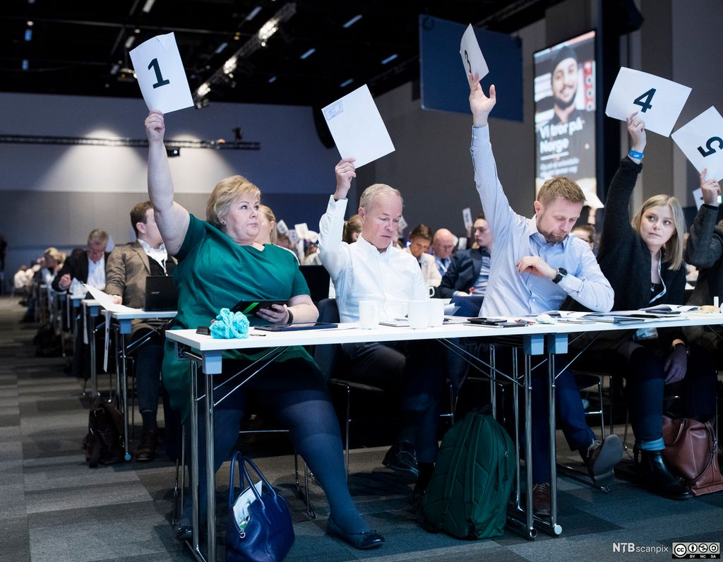Sentrale høyrepolitikere holder stemmesedler i været. Foto.